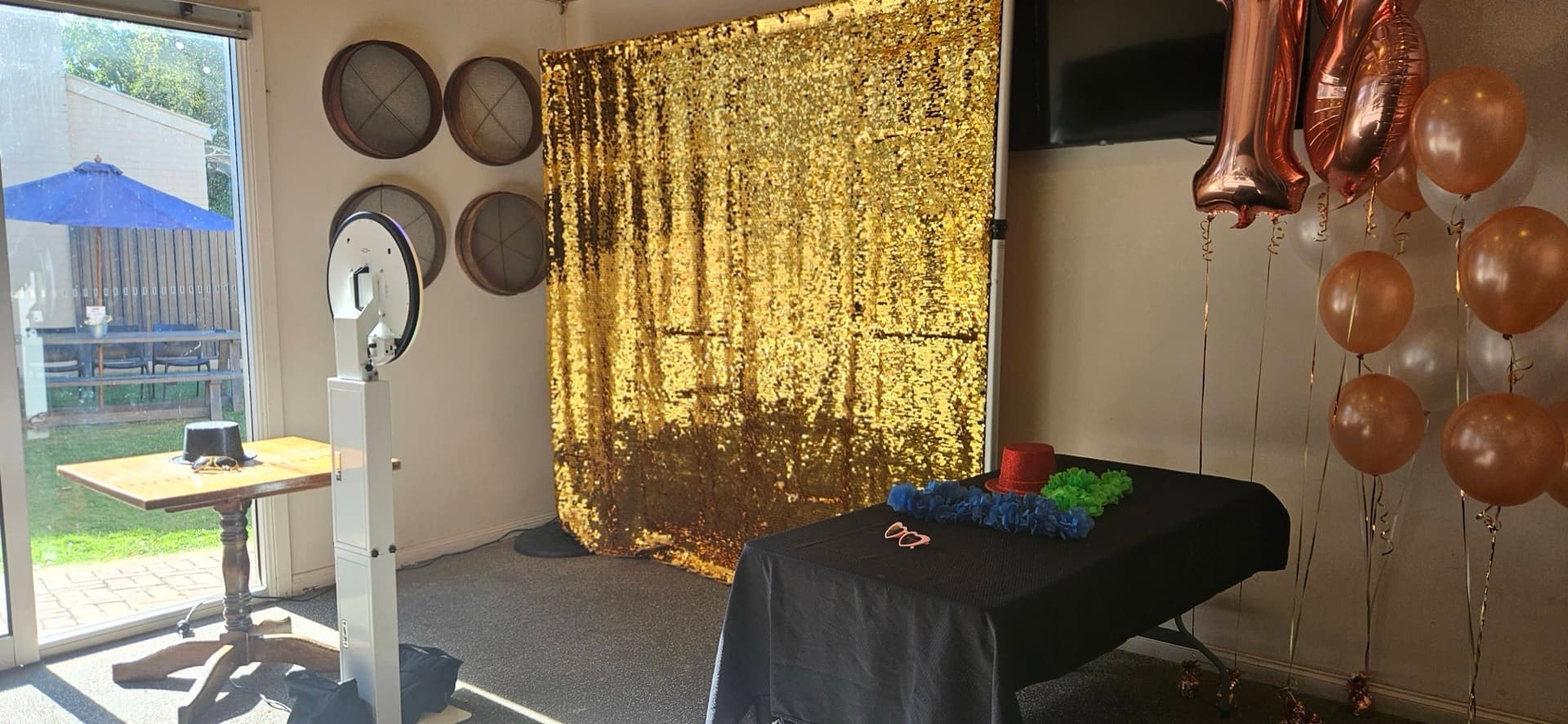 Photo booth setup with a gold sequin backdrop